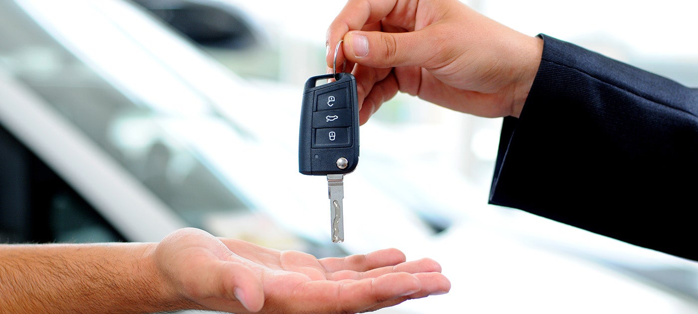Close up image of a car representative handing off keys to a customer - Al Serra Chevrolet in Grand Blanc MI